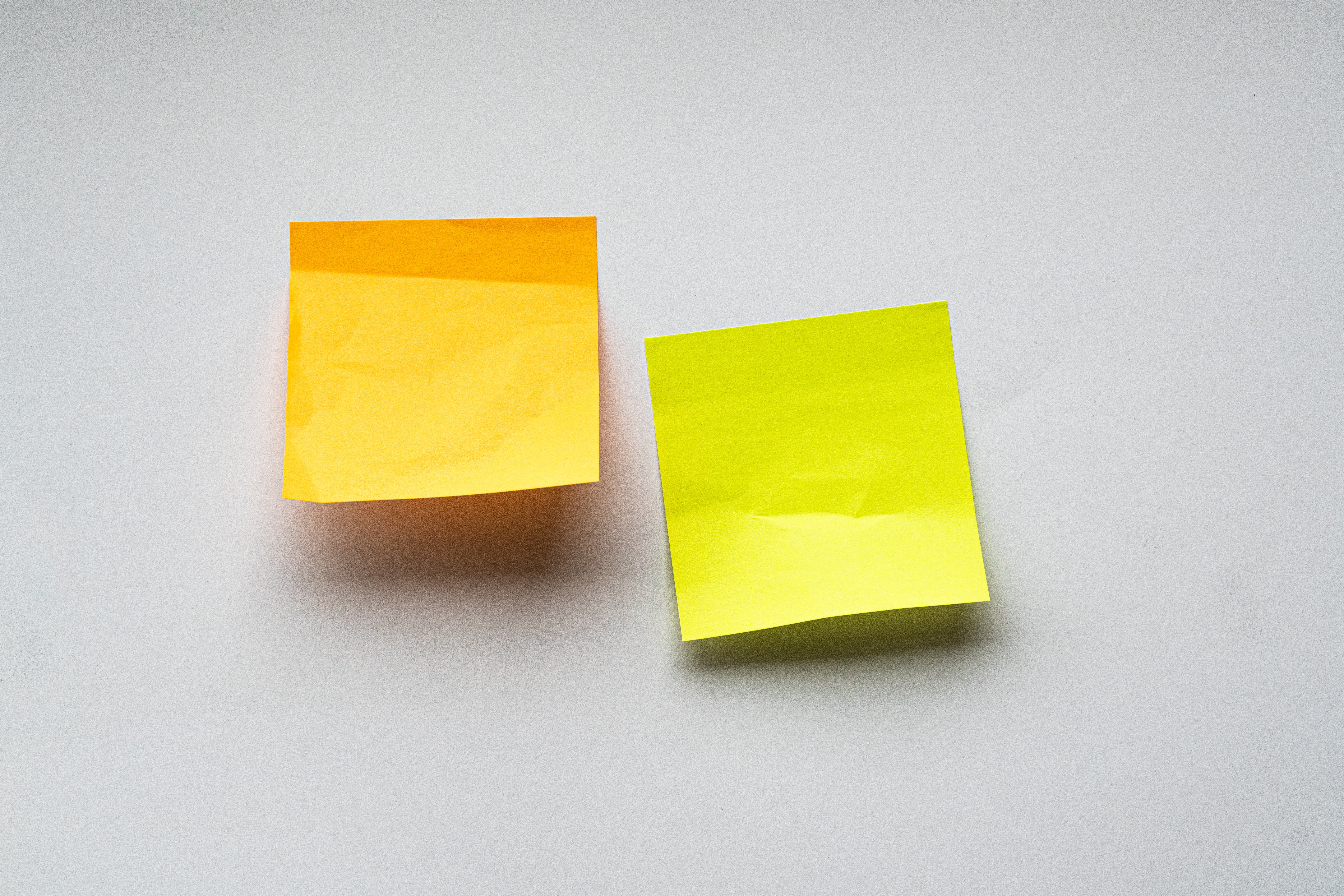 closeup image of two post-it notes stuck on a wall